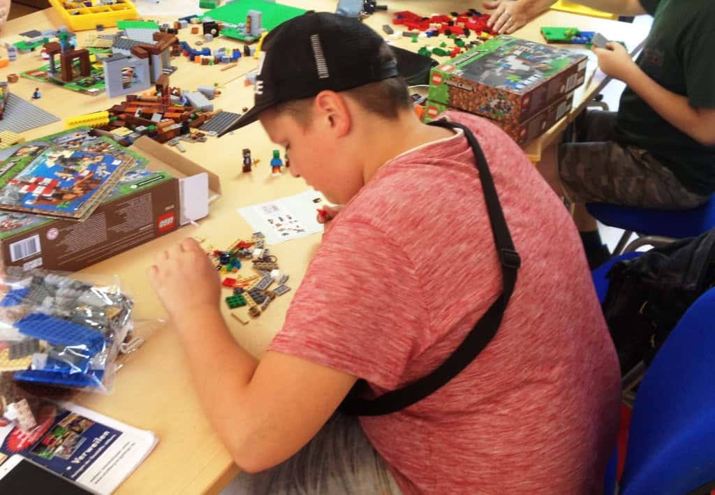 Teenager spielt mit Lego-Bausteinen