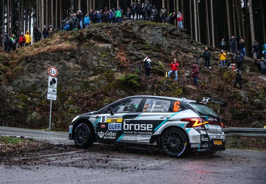 Rallye-Fahrzeug mit Zuschauern auf Felsen